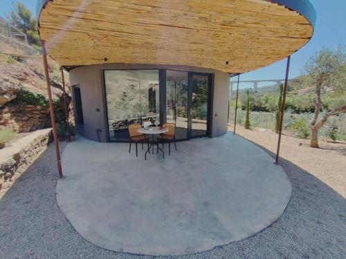 een klein huis met een ronde patio met een tafel en stoelen bij Villa Vasca by Interhome in Civezza