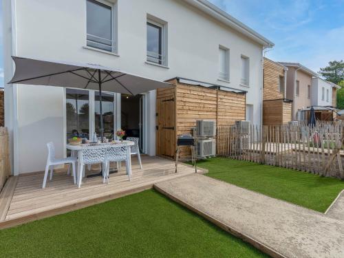 a patio with a table and an umbrella at Apartment Soleil Couchant B03 by Interhome in Mimizan
