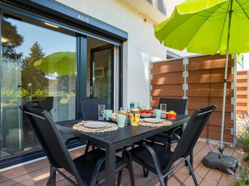 a black table with chairs and an umbrella on a patio at Apartment Juventus by Interhome in Balatonföldvár