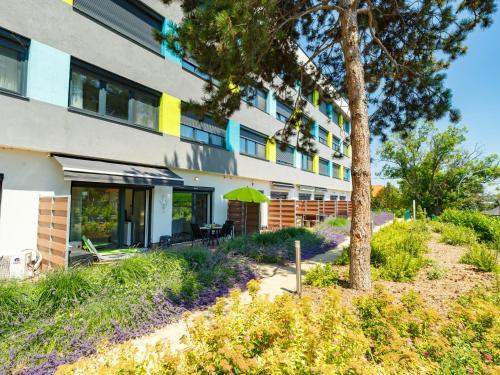 a building with a tree in front of it at Apartment Juventus by Interhome in Balatonföldvár