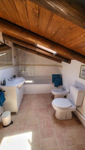 ein Badezimmer mit 2 WCs, einem Waschbecken und einer Badewanne in der Unterkunft Casa Aventura in Boliqueime