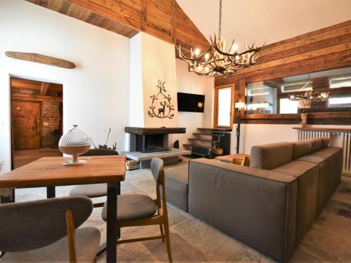 a living room with a couch and a table and a fireplace at Chalet Baita Barin by Interhome in Madesimo