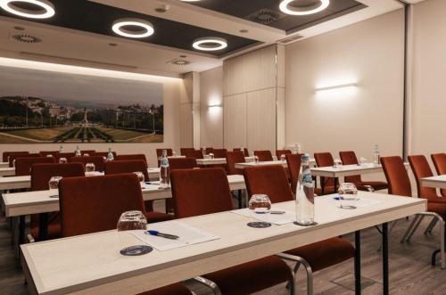 a conference room with tables and chairs and a painting at Hotel Marques De Pombal in Lisbon