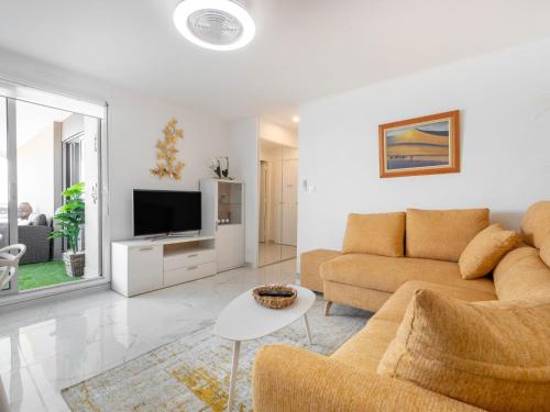salon z kanapą i telewizorem w obiekcie Apartment Terrasses du Levant by Interhome w mieście Canet-en-Roussillon