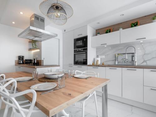 une cuisine avec une table en bois et des armoires blanches dans l'établissement Apartment Terrasses du Levant by Interhome, à Canet
