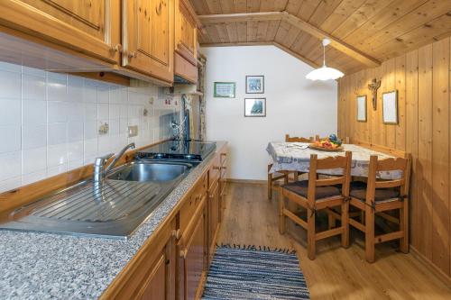 a kitchen with a sink and a table at Ciasa Rü in San Cassiano