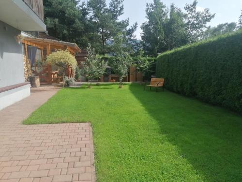 a yard with a bench and a hedge at Zakątek DoriMaks in Zawoja