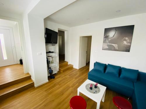 ein Wohnzimmer mit einem blauen Sofa und roten Stühlen in der Unterkunft Gogalova Apartments in Ljubljana