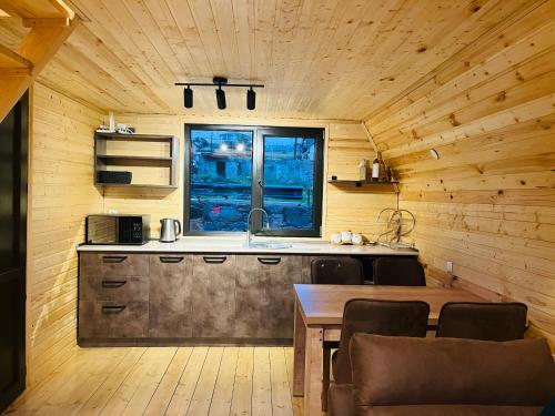 a kitchen with a sink and a table with chairs at Cottage Carpe Diem in Stepantsminda