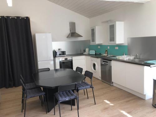 uma cozinha com mesa e cadeiras num quarto em Maison 80m2 entièrement rénovée à 1,5km de la plage des Conches em Longeville-sur-Mer