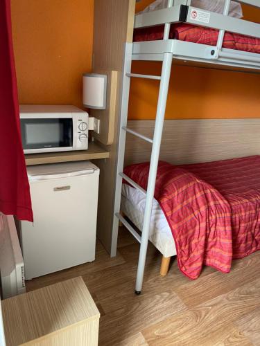 a room with a bunk bed with a microwave and a bunk bed at Premiere Classe Beauvais in Beauvais
