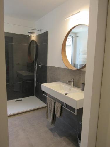 a bathroom with a sink and a mirror and a shower at Make a wish - near the center with private parking in Como