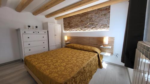 um quarto com uma cama e uma parede de tijolos em Casa lagunare haus em Chioggia
