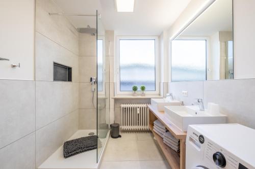 La salle de bains est pourvue d'un lavabo et d'un lave-linge. dans l'établissement Ferienwohnung Alpenzeit, à Oberstaufen