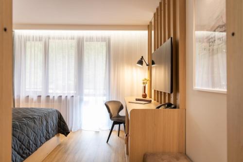 a bedroom with a bed and a desk with a computer at Cabana Bistrita in Durau