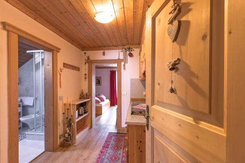 a hallway with a wooden door and a room at Ciasa Rü in San Cassiano