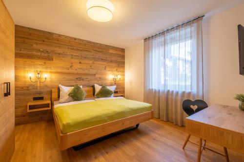 a bedroom with a bed with a wooden wall at Ferienwohnung Alpenzeit in Oberstaufen