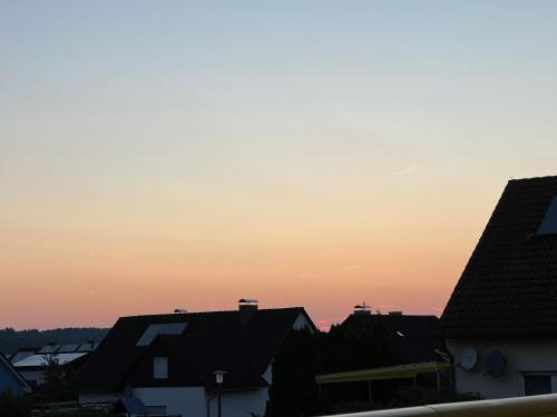 a sunset over roofs of houses in a city at Familie Ising in Wörnitz