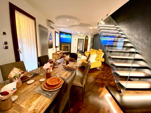 a living room with a dining table and a staircase at Wood Luxury House in Pescara