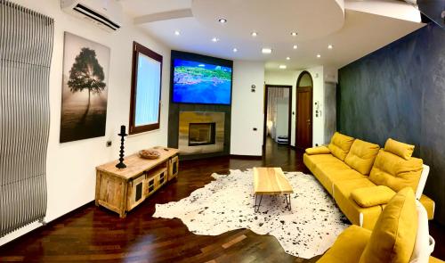 a living room with a yellow couch and a tv at Wood Luxury House in Pescara
