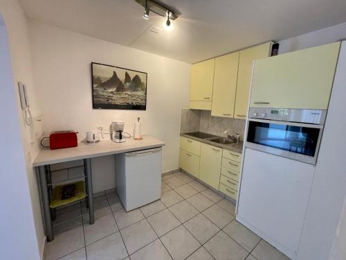 eine Küche mit gelben Schränken und einem weißen Kühlschrank in der Unterkunft Apartment Locarno-Lido in Locarno