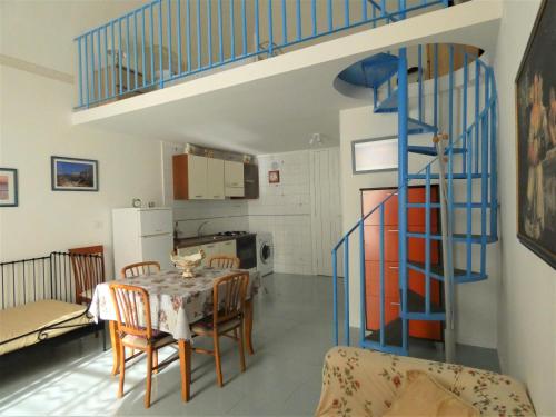 uma sala de estar com uma mesa e uma escada azul em espiral em House Sasanelli em Bari