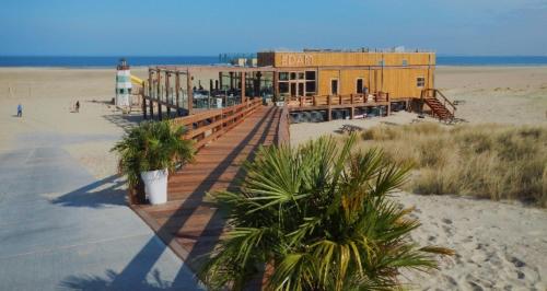 a building on the beach next to a beach at ZP 508 - Camping de Zandput in Vrouwenpolder