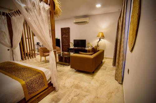 a bedroom with a bed and a living room at Coastline Resort in Mussanah