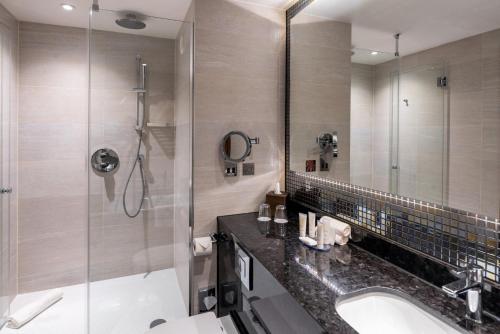 a bathroom with a shower and a sink and a mirror at Crowne Plaza London Heathrow T4, an IHG Hotel in Hillingdon