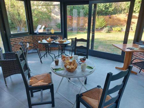une salle à manger avec tables, chaises et fenêtres dans l'établissement Résidence Honfleuraise, à Honfleur