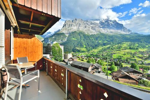 een balkon met een tafel en uitzicht op een berg bij Studio Eigerblick in Grindelwald