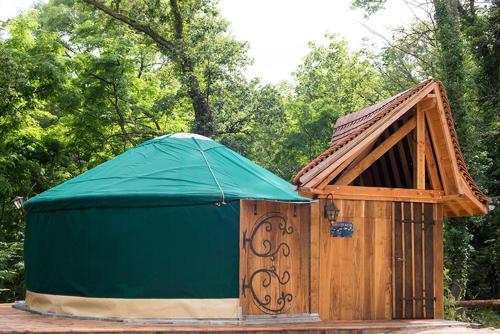 a wooden out house with a green tent at Yourte La Désirade in Semur-en-Auxois