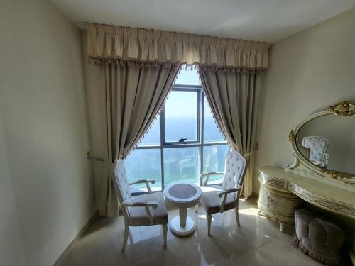 a dining room with a table and chairs and a mirror at Beachfront Holiday Homes in Ajman 