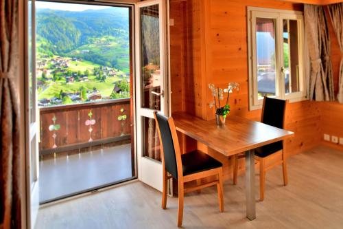 een eetkamer met een tafel en een groot raam bij Studio Eigerblick in Grindelwald