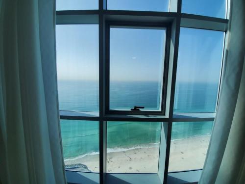 a view of the ocean from a window at Beachfront Holiday Homes in Ajman 