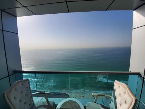 a view of the ocean from a room with chairs at Beachfront Holiday Homes in Ajman 