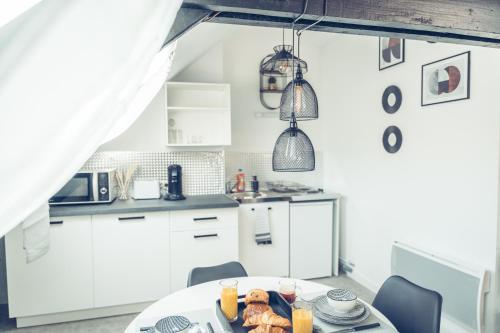 une cuisine avec une table avec de la nourriture dessus dans l'établissement Le loft superbe studio avec stationnement gratuit, à Dunkerque