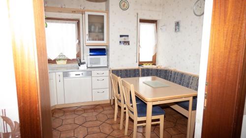 a small kitchen with a table and chairs in it at Grosse-Ferienwohnung-ueber-2-Etagen-bei-Frankfurt in Niederdorfelden
