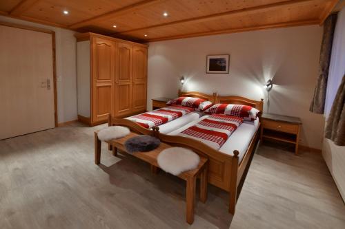 Studio Eigerblick في جريندلفالد: غرفة نوم بسرير كبير ومخدات حمراء وبيضاء