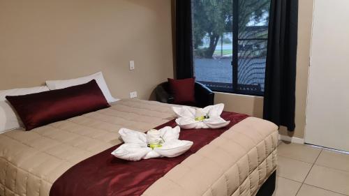 sypialnia z łóżkiem z białymi kwiatami w obiekcie Boggabri Motel w mieście Boggabri