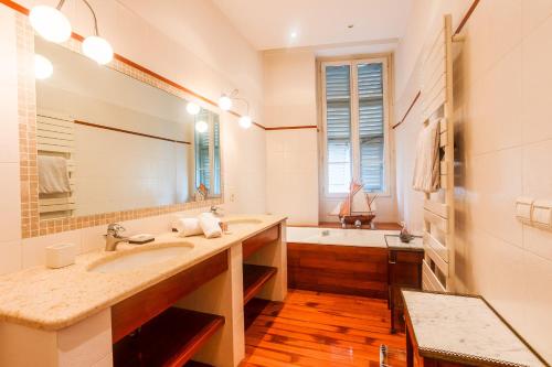 une salle de bain avec un lavabo, une baignoire et un miroir dans l'établissement PALAIS ALBERT 1ER AP4292 By Riviera Holiday Homes, à Nice
