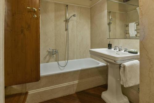 a bathroom with a tub and a sink and a shower at Tiepolo romantic penthouse in the Oltrarno in Florence