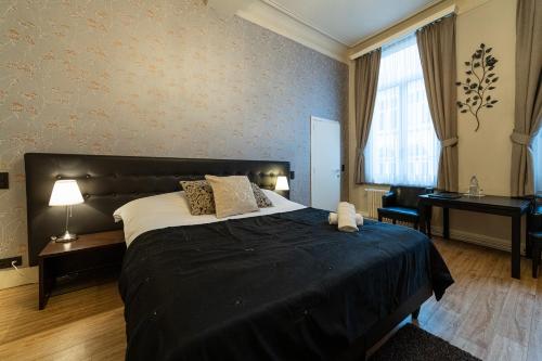 a bedroom with a large bed and a piano at Hotel Onderbergen in Ghent