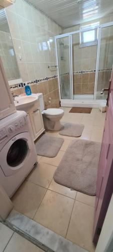 a bathroom with a washing machine and a toilet at Cleopatra plajına 50mt deniz gören ferah 2+1 daire in Alanya