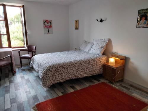 a bedroom with a bed and a table and a window at La Petite Auberge in Lorquin