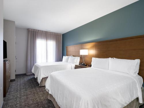a hotel room with two beds and a window at Staybridge Suites - Sioux City Southeast by IHG in Sioux City