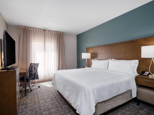 a hotel room with a large bed and a television at Staybridge Suites - Sioux City Southeast by IHG in Sioux City