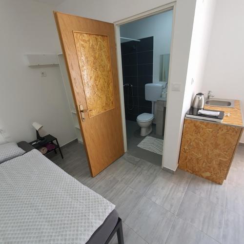 a bedroom with a door and a bathroom with a toilet at Budget Apartment LeLo Center 4 in Osijek