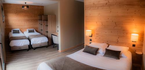 1 Schlafzimmer mit 2 Betten und einer Holzwand in der Unterkunft Hôtel Le Picors in Aucun