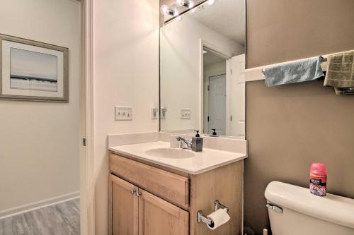 a bathroom with a sink and a mirror and a toilet at Porch and Community Perks Walkable Lewes Condo in Lewes